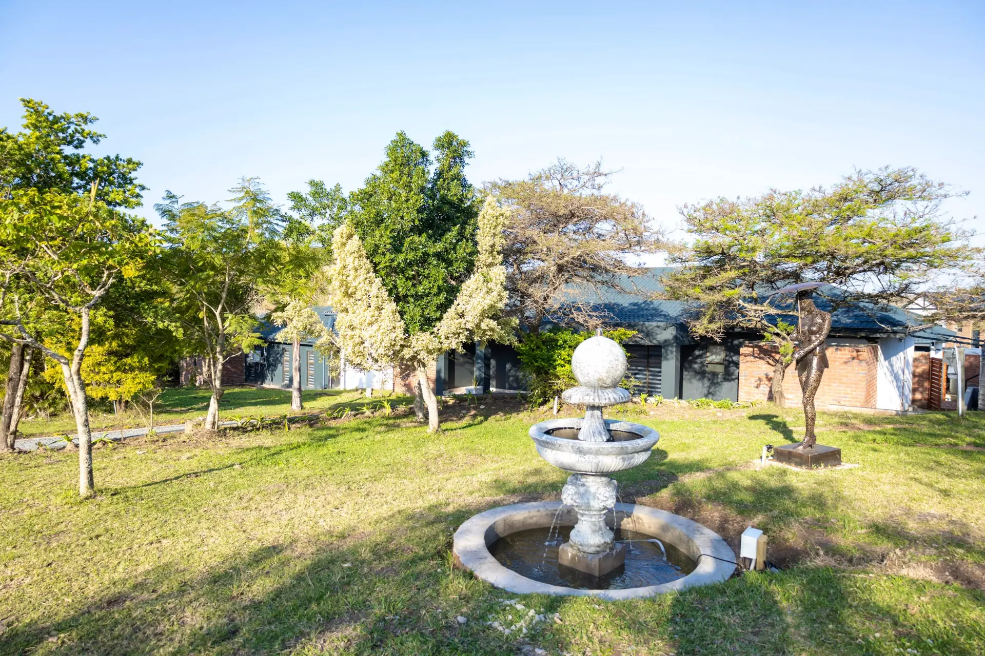 Farm gardens with a stone fountain and sculpture